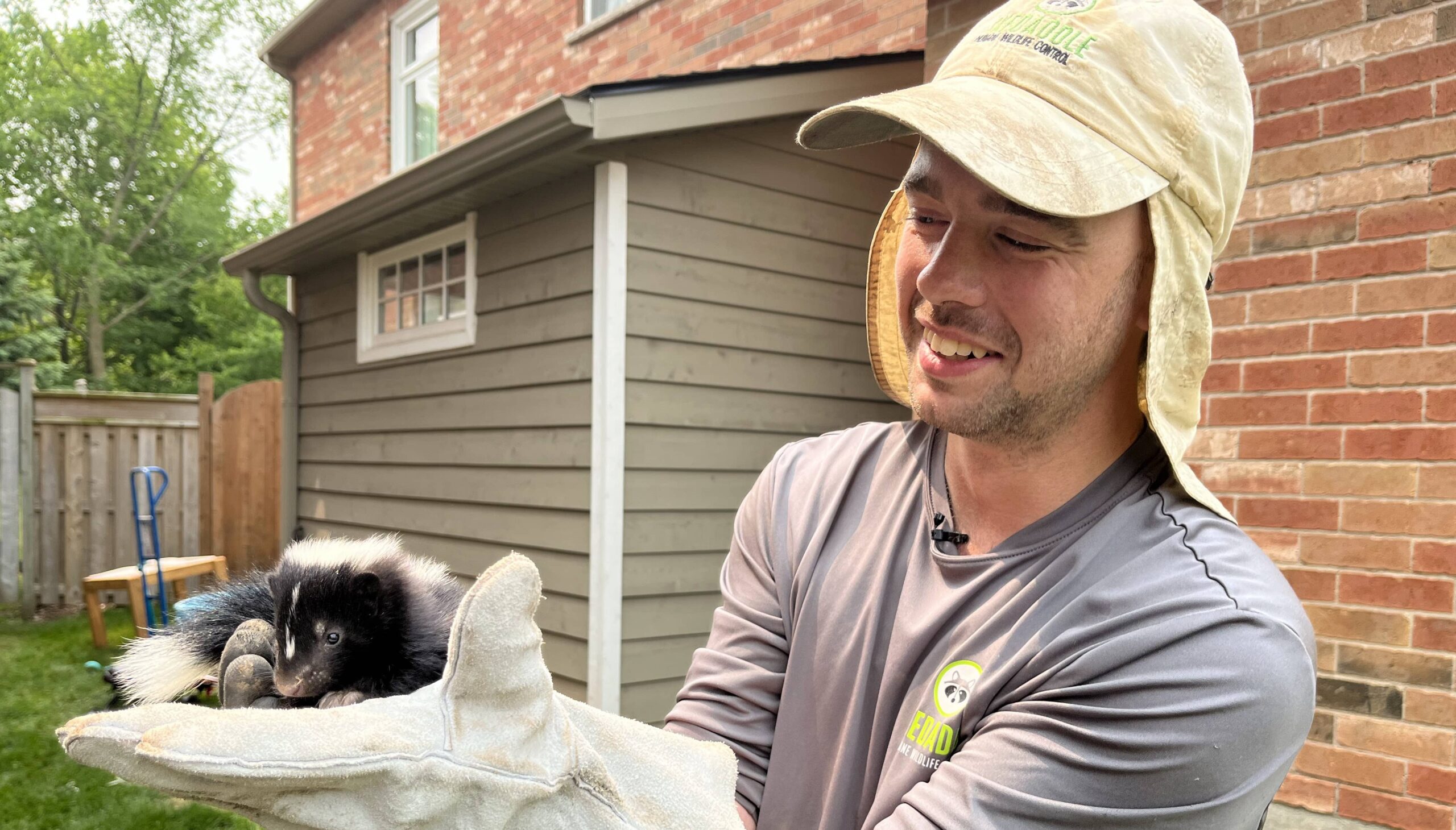 Skedaddle technician hold baby skunk (1) (1)